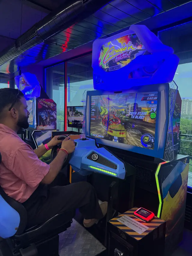 A team member at an arcade driving game