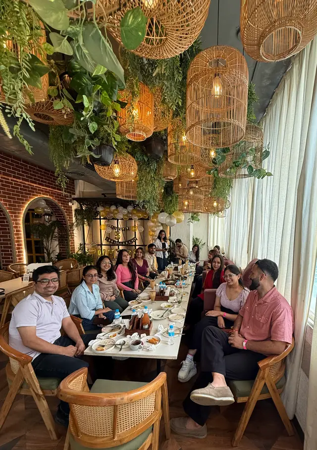 The team smiling around the anniversary lunch table